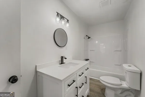 a bathroom with a sink a toilet and a mirror