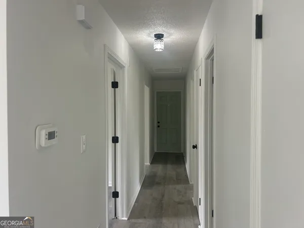 a view of a hallway with closet and bathroom