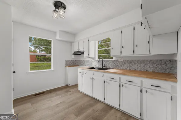a kitchen with granite countertop white cabinets and window