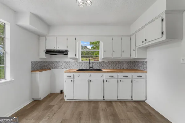 a kitchen with granite countertop white cabinets and a sink