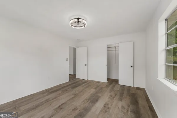 a view of a room with wooden floor and a window