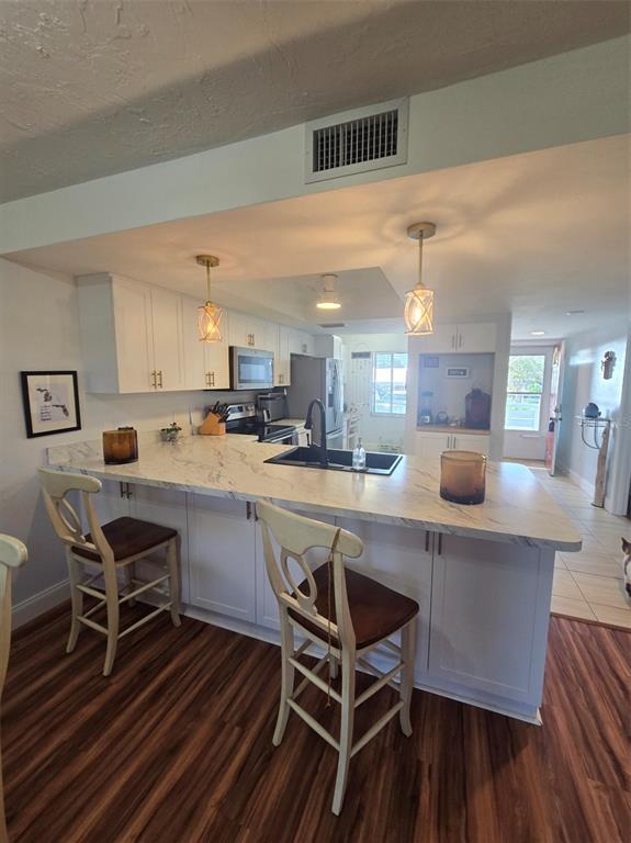 6800 Placida Road, Unit 167 Englewood, FL 34224 - Photo 17 of 44 a kitchen with a dining table chairs and white cabinets