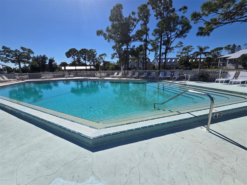 6800 Placida Road, Unit 167 Englewood, FL 34224 - Photo 43 of 44 a view of a pool with a bench and trees in the background