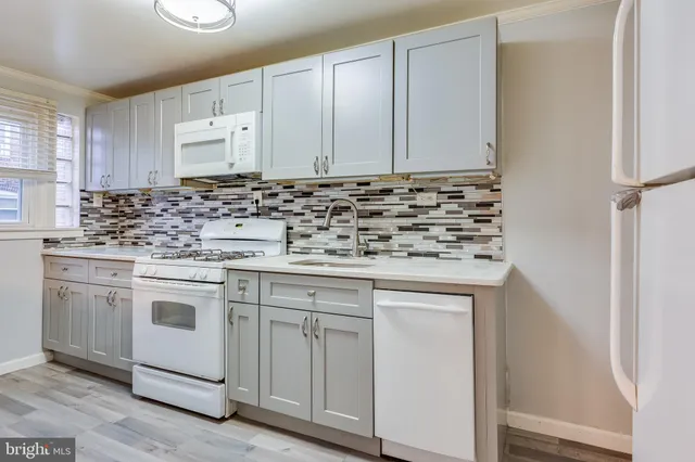 a kitchen with white cabinets and white appliances