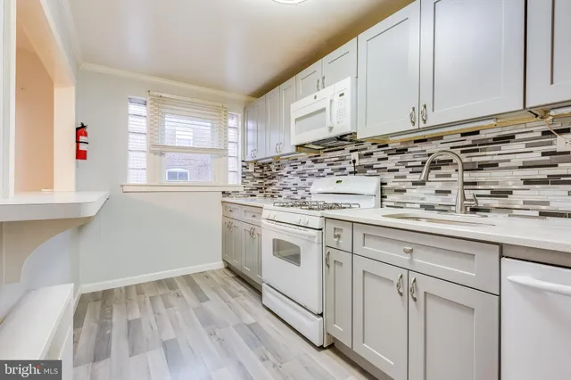 a white kitchen with granite countertop white cabinets and white appliances