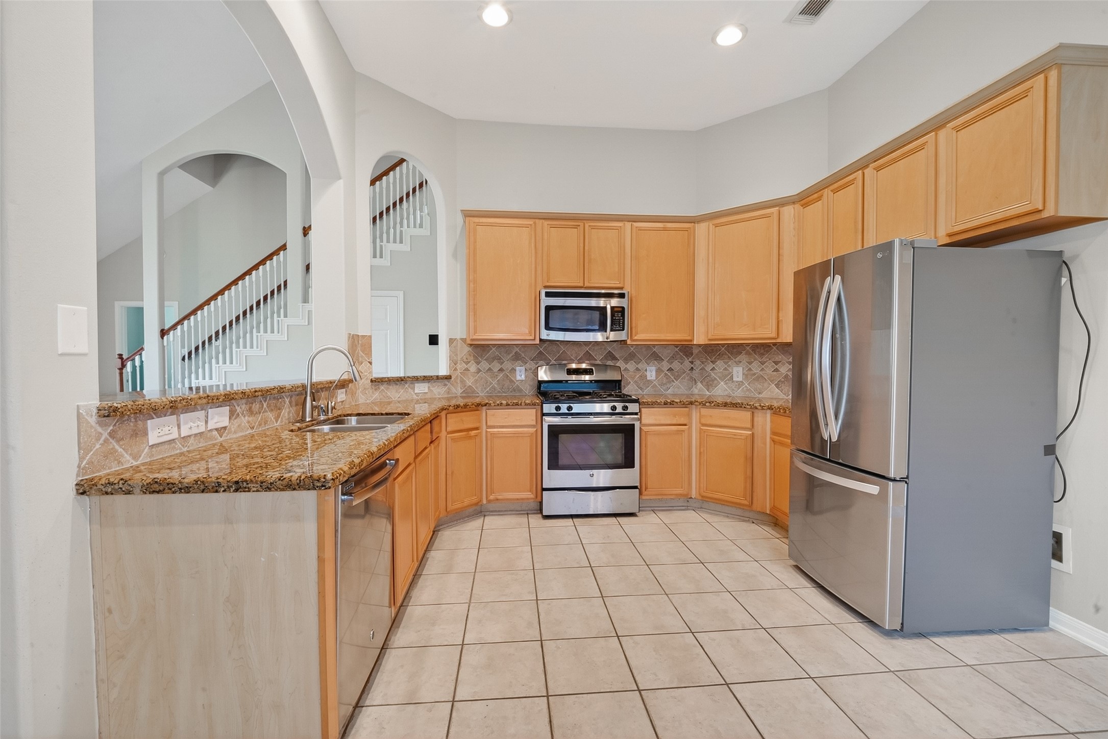 14308 Rocky Briar Lane Rosharon, TX 77583 - Photo 12 of 46 a kitchen with stainless steel appliances granite countertop a refrigerator sink and stove