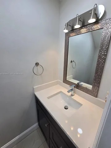 a bathroom with a sink vanity and mirror