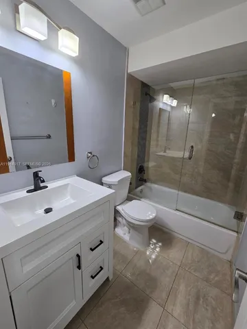 a bathroom with a double vanity sink toilet and shower