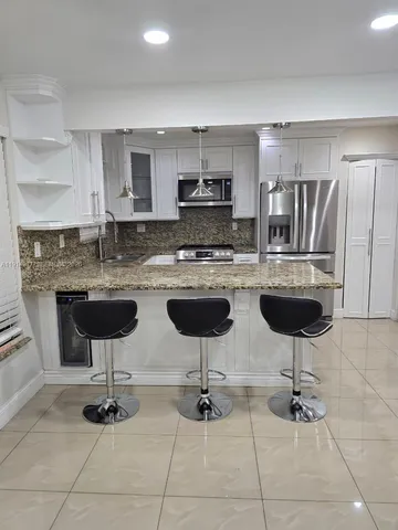 a kitchen with stainless steel appliances kitchen island granite countertop a sink and cabinets