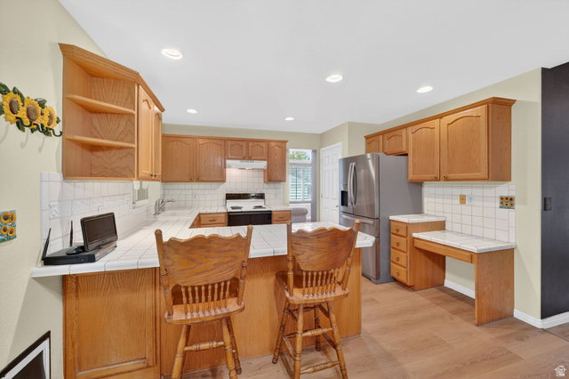 1464 990 West Provo, UT 84601 - Photo 12 of 41 Kitchen with wood cabinetry, white tile countertops, and a full suite of stainless steel appliances