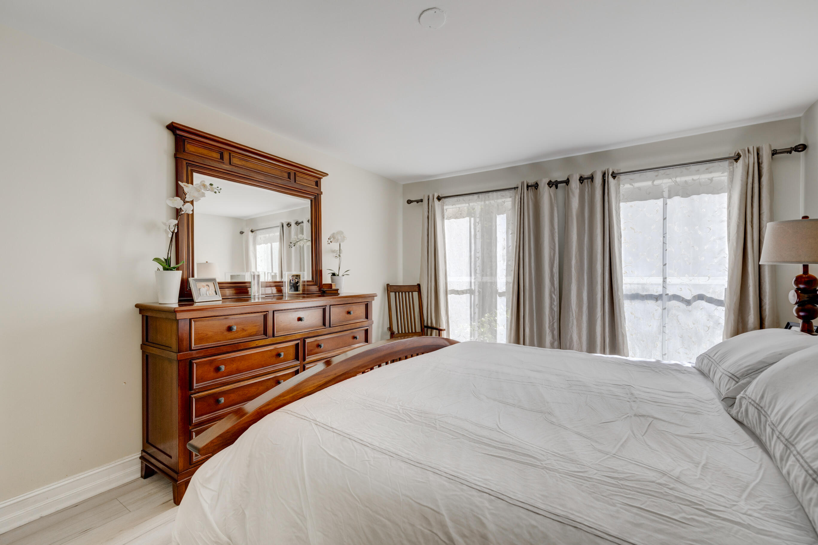995 Riverside Drive, Unit 111 Coral Springs, FL 33071 - Photo 12 of 24 a bedroom with a bed and a large mirror on dresser