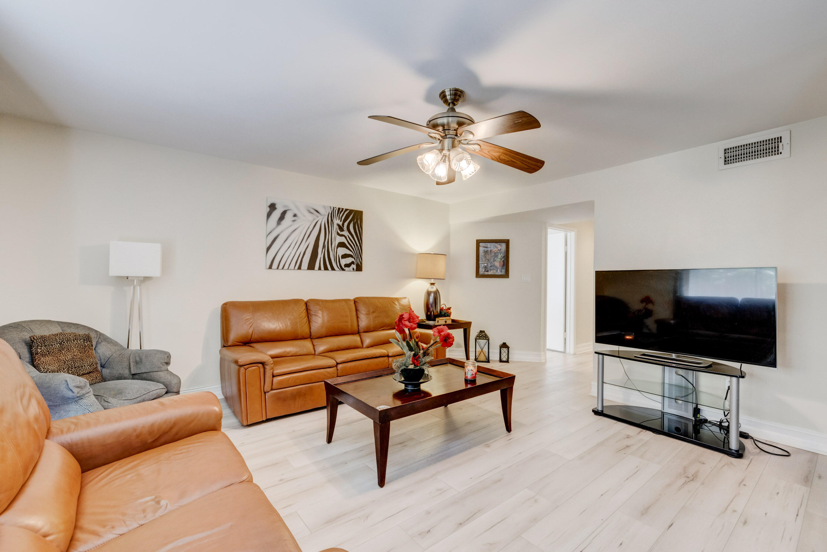 995 Riverside Drive, Unit 111 Coral Springs, FL 33071 - Photo 4 of 24 a living room with furniture and a flat screen tv