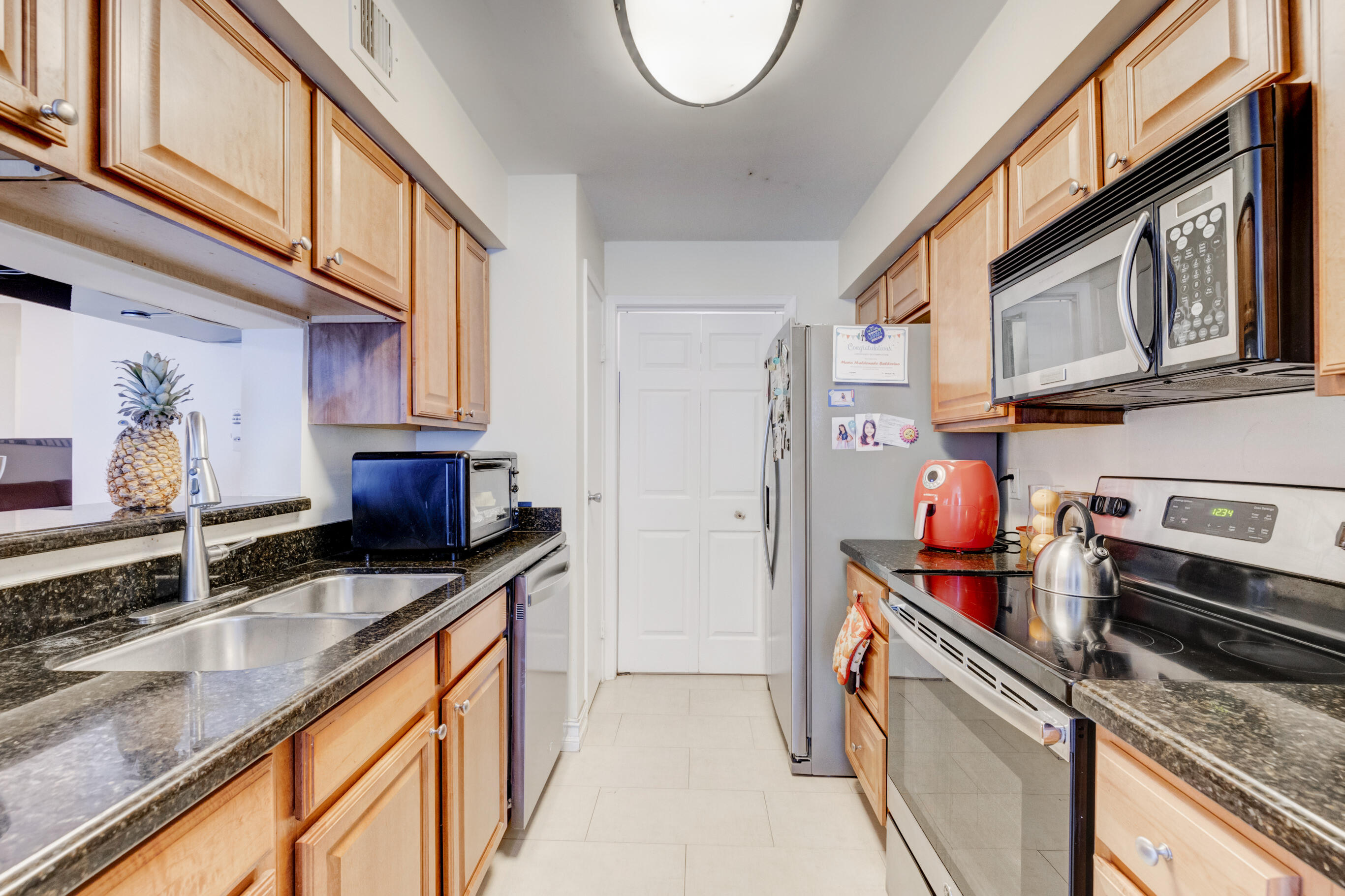 995 Riverside Drive, Unit 111 Coral Springs, FL 33071 - Photo 8 of 24 a kitchen with stainless steel appliances granite countertop a sink stove and cabinets