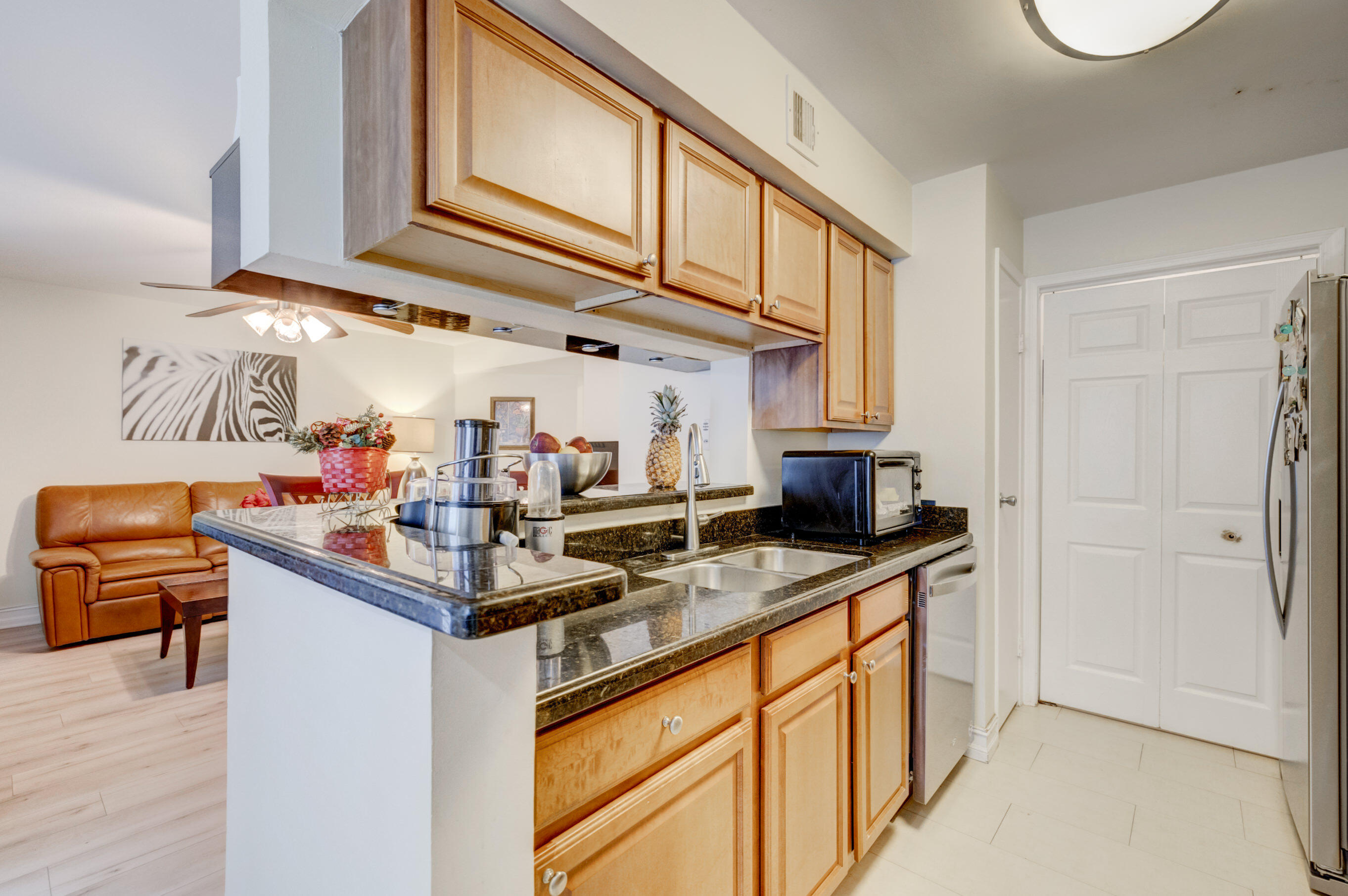 995 Riverside Drive, Unit 111 Coral Springs, FL 33071 - Photo 9 of 24 a kitchen with stainless steel appliances granite countertop a sink and cabinets