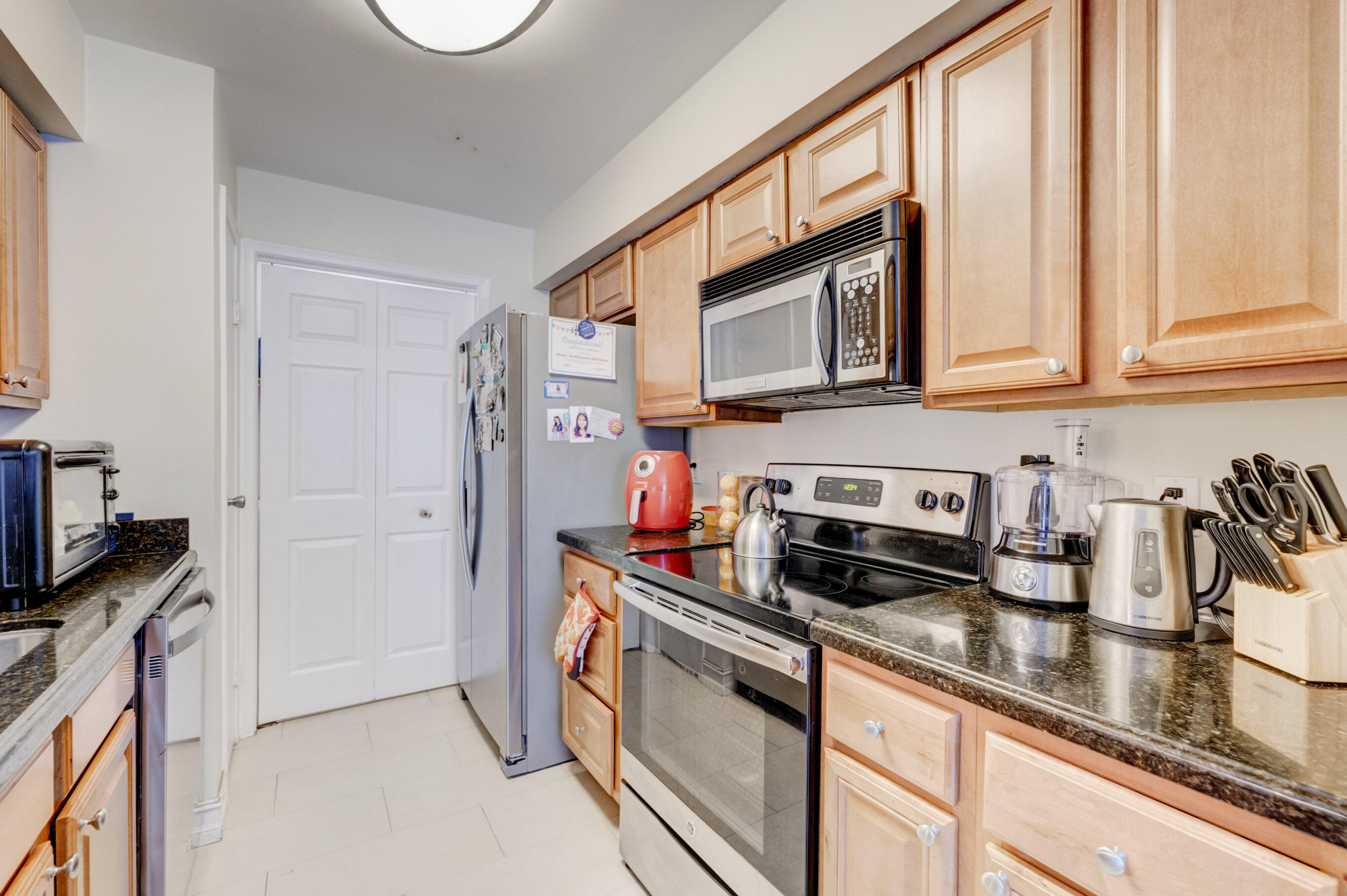 995 Riverside Drive, Unit 111 Coral Springs, FL 33071 - Photo 10 of 24 a kitchen with stainless steel appliances granite countertop a stove a sink and a microwave