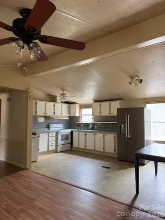 a large kitchen with a wooden floor and cabinets