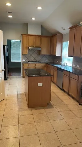 a kitchen with stainless steel appliances a sink a counter and stove