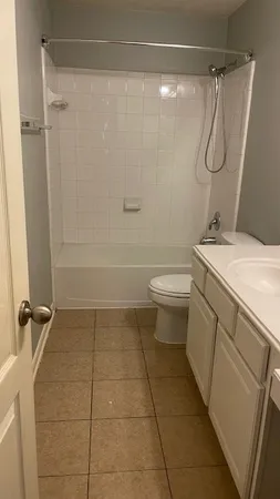 a bathroom with a granite countertop sink a toilet and a shower