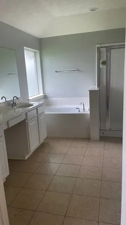 a bathroom with a granite countertop bathtub sink vanity and mirror