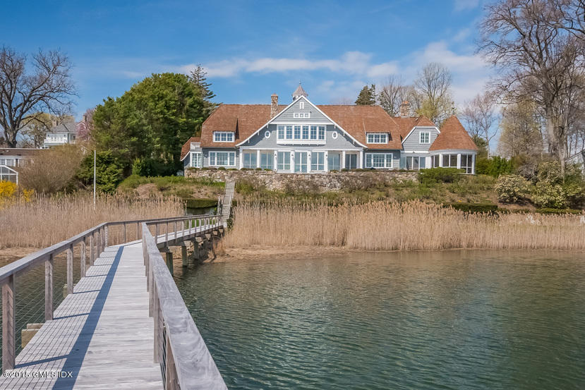 141 Long Neck Point Road Darien, CT 06820 - Photo 3 of 7 a view of a brick house next to a lake with a large trees