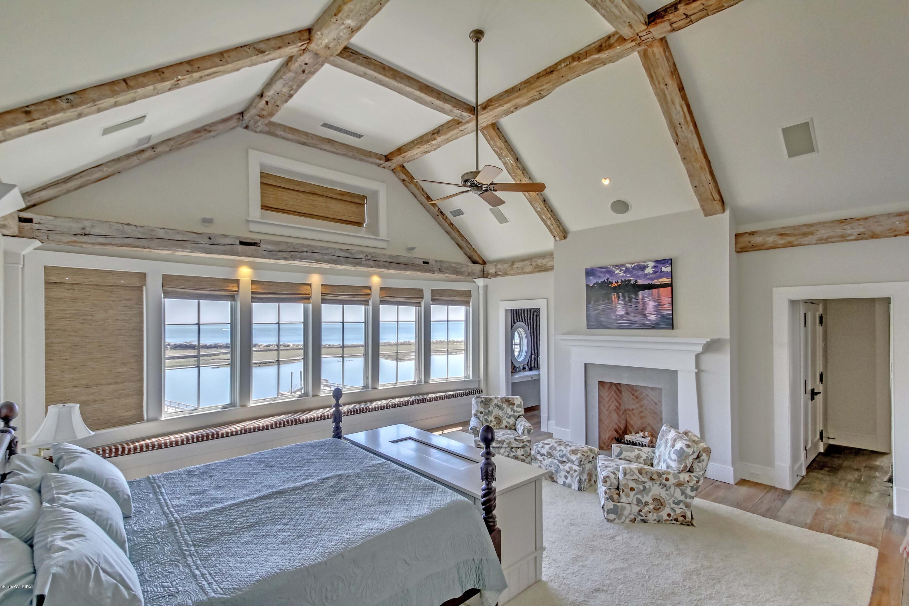 141 Long Neck Point Road Darien, CT 06820 - Photo 7 of 7 a spacious bedroom with a balcony a bed and a fireplace