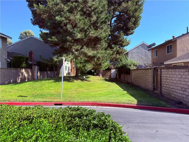 a view of a backyard with plants and brick house
