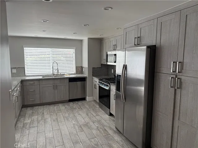 a kitchen with granite countertop a refrigerator and a sink