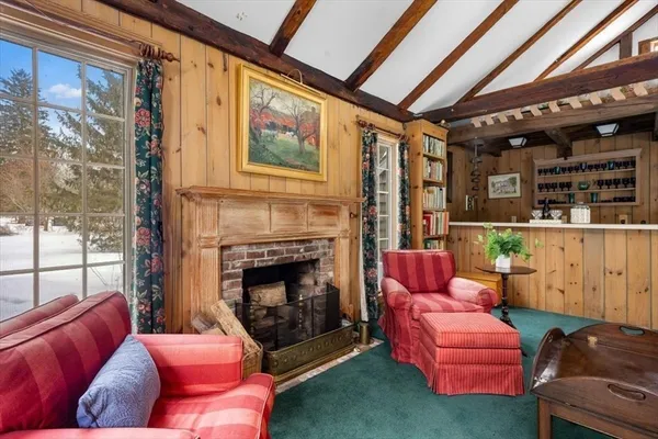 a living room with furniture a fireplace and next to a window