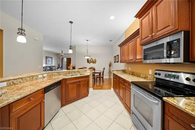 a large kitchen with stainless steel appliances granite countertop a stove a sink and a microwave