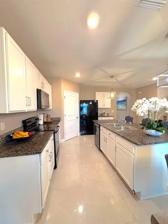 a kitchen with stainless steel appliances granite countertop a stove a sink and a microwave