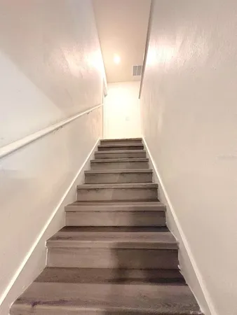 a spacious bedroom with a bed and a view of kitchen