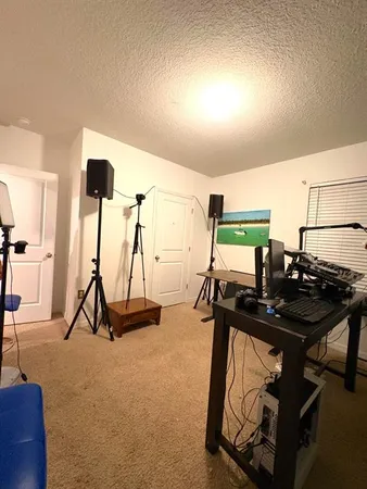 a room with a bed and large windows