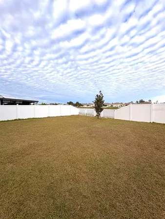 an aerial view of residential houses with outdoor space and parking