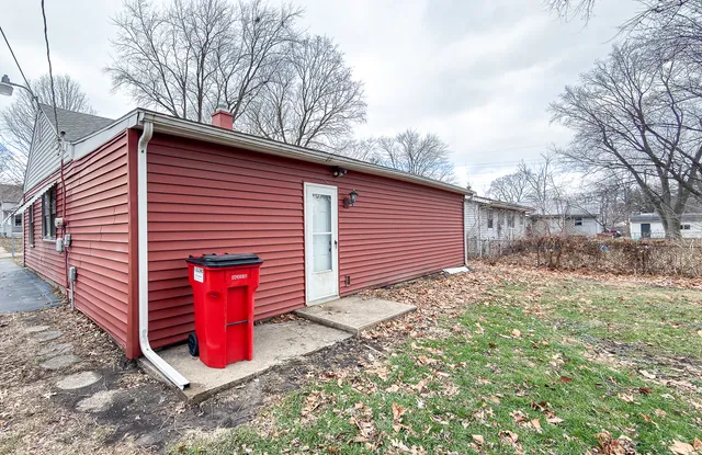 a view of a small house with yard and garage