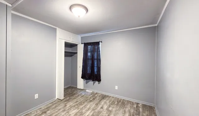 an empty room with closet and mirror