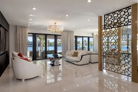 a living room with furniture and floor to ceiling windows