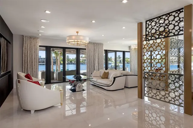 a living room with furniture and floor to ceiling windows