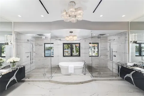 a bedroom with a large bed and a chandelier