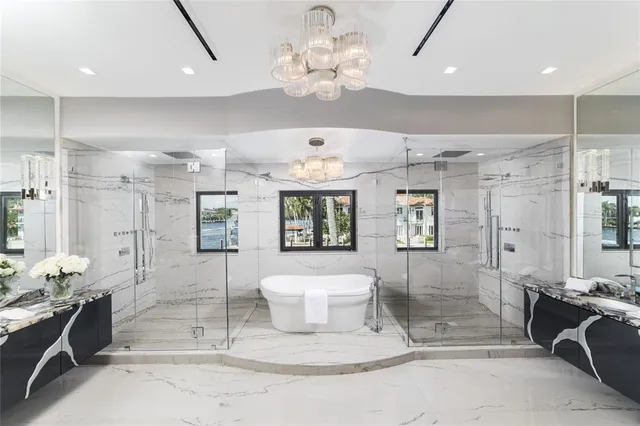 a bedroom with a large bed and a chandelier