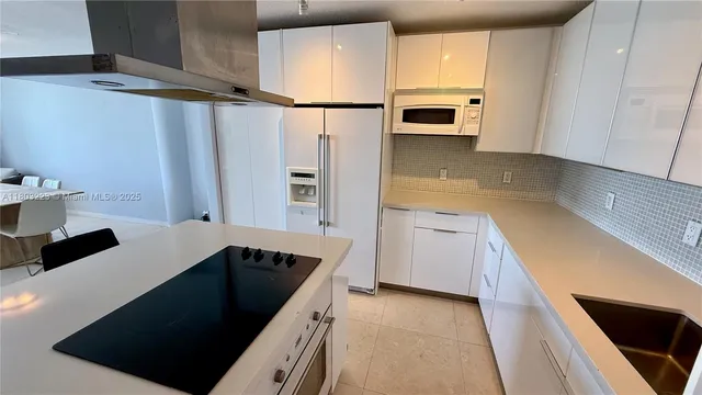 a kitchen with granite countertop a refrigerator and a sink