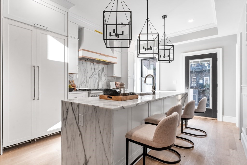 210 West Springfield Street, Unit 2 Boston, MA 02118 - Photo 16 of 33 a kitchen with stainless steel appliances kitchen island a table chairs in it and wooden floors