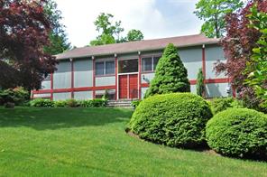 a view of a house with a yard and potted plants