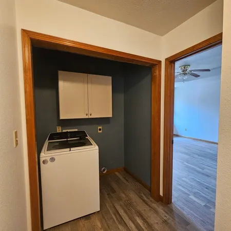 a utility room with wooden floor washer and dryer