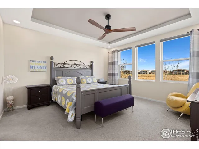 a bedroom with a bed dresser flowerpot and window