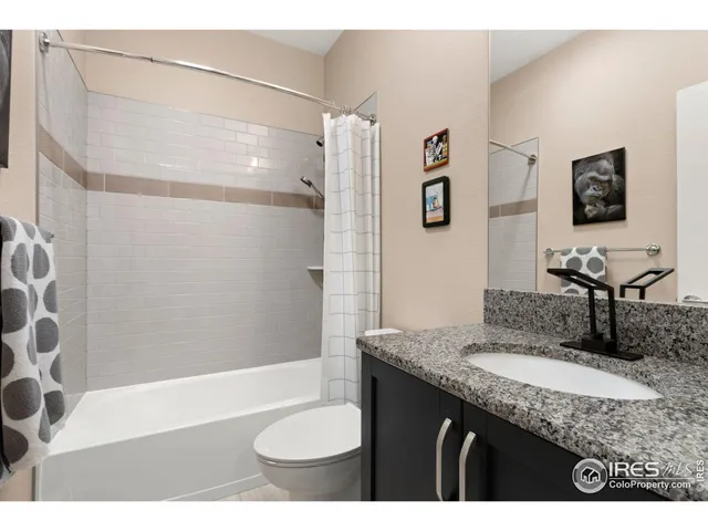 a bathroom with a granite countertop sink a mirror a bathtub and shower
