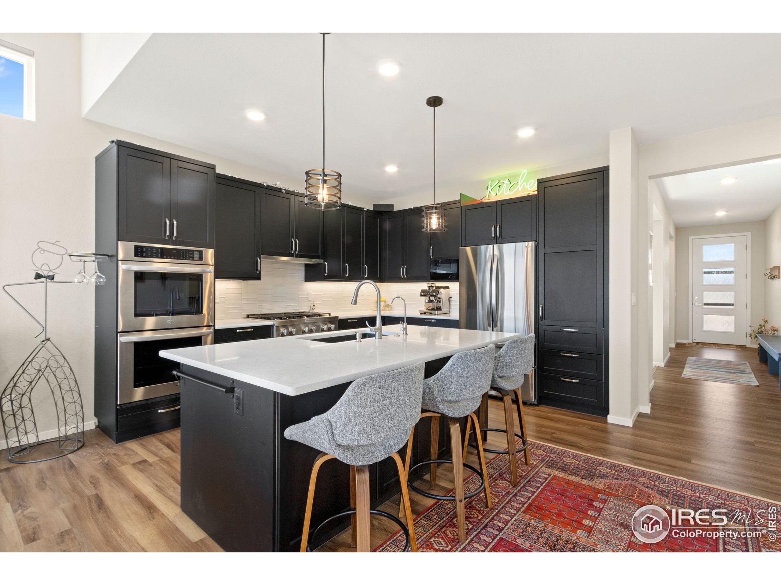 6808 Castello Street Timnath, CO 80547 - Photo 7 of 22 a kitchen with kitchen island a sink stove and refrigerator