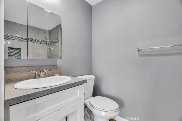 a bathroom with a sink toilet and a mirror