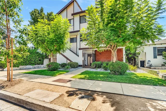 front view of a house with a yard and an trees