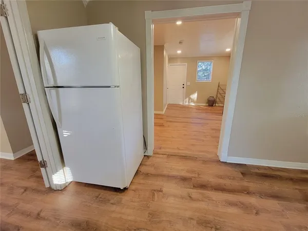 a view of a hallway with wooden floor and a cabinet