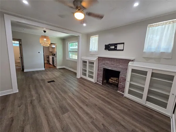 wooden floor fireplace and windows in an empty room